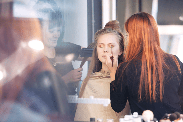 woman applying makeup on model
